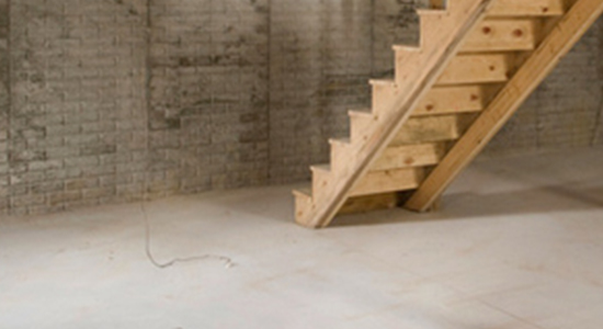 Wood stairs going to a concrete basement | Concrete flooring services by Rob & Theresa Schwartz Contracting
